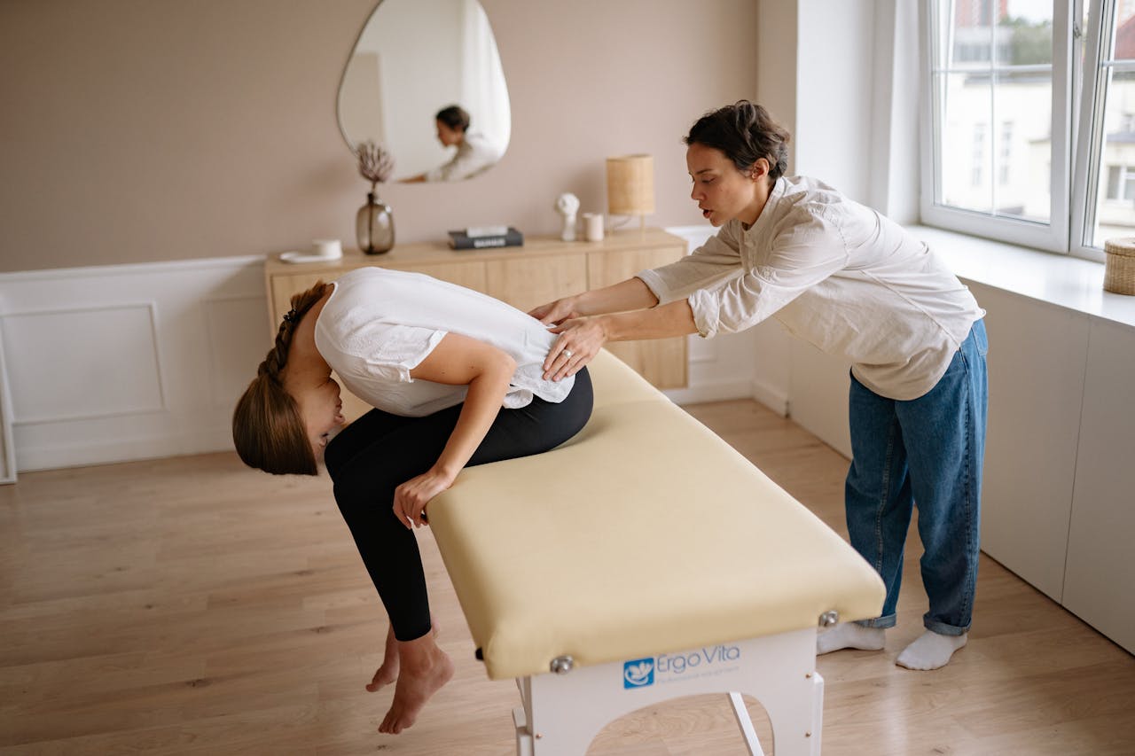 Therapist providing a relaxing back massage treatment to a client indoors on a massage table.